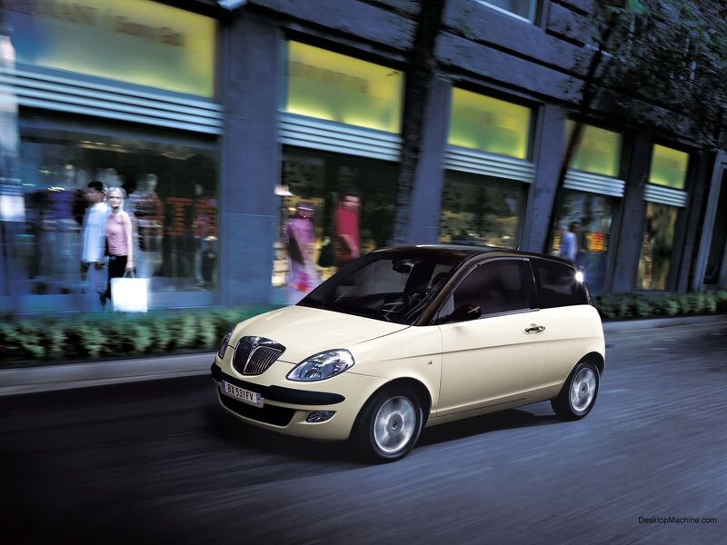 Beige car driving on city street