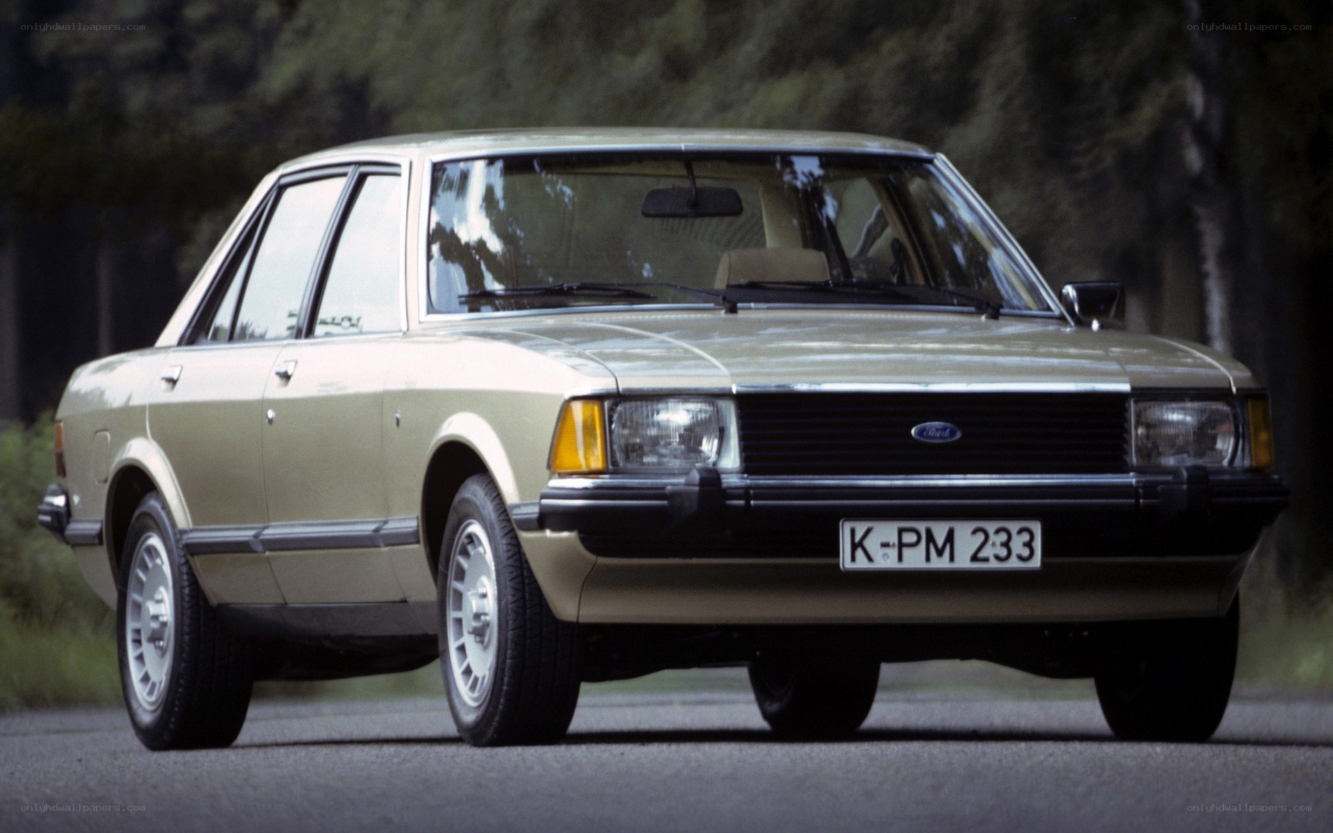 beige ford sedan on road