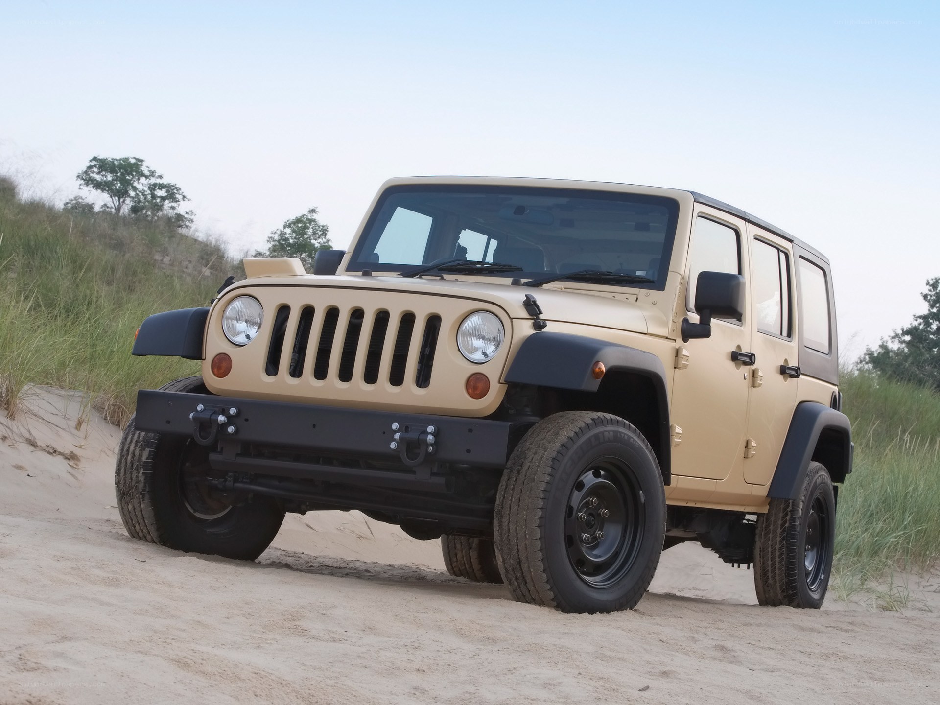 Beige Jeep on a sandy dune