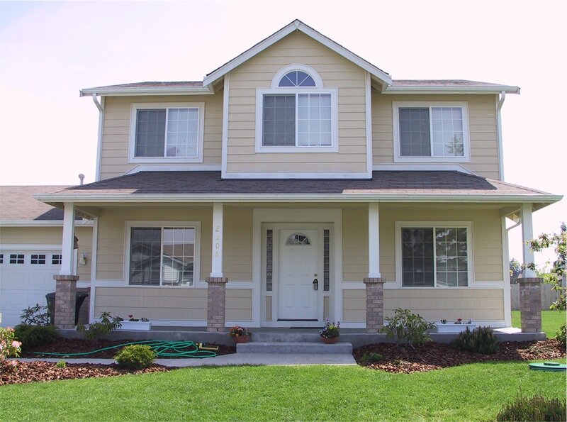 beige two-story house with porch