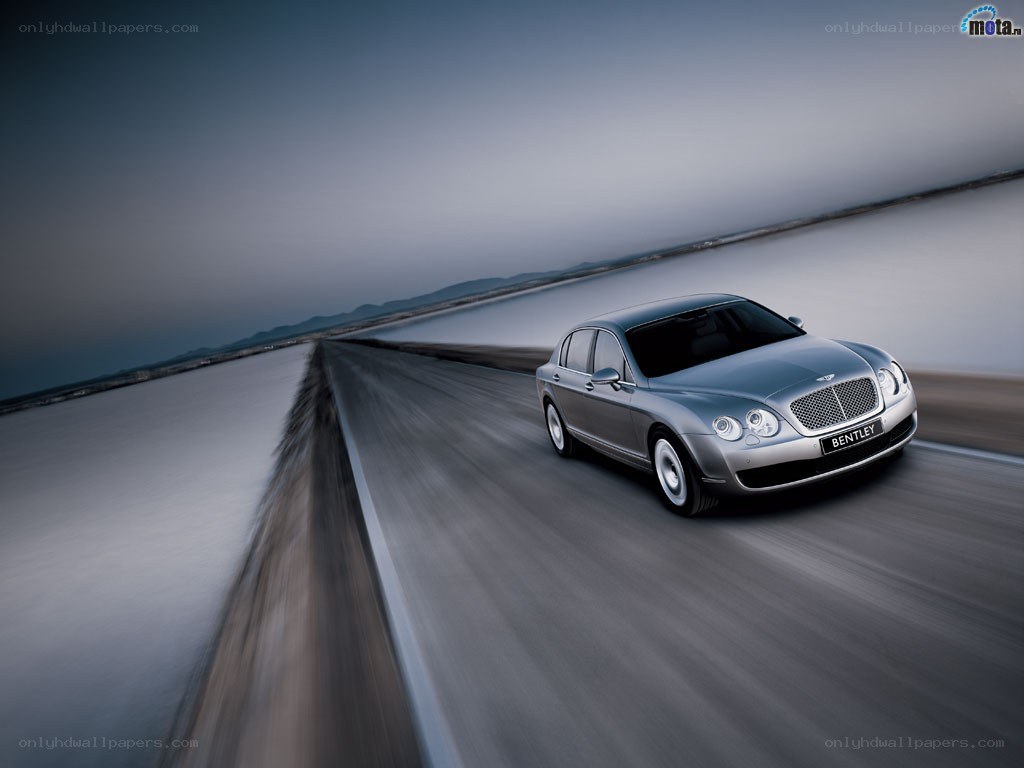 Bentley driving on a coastal road