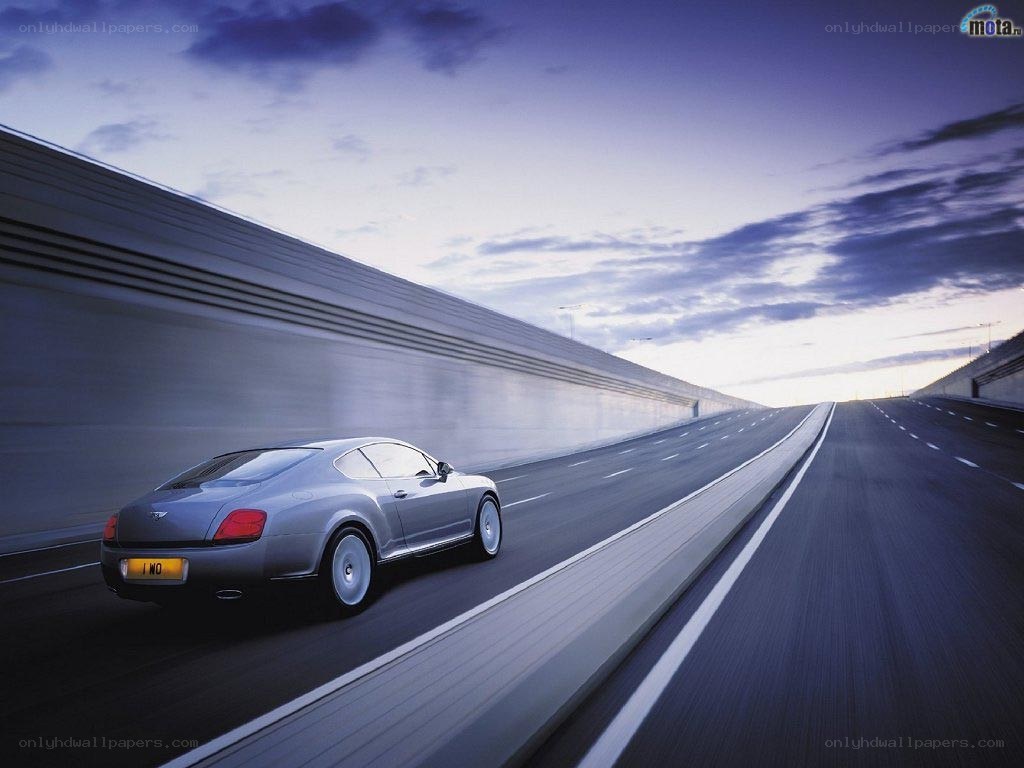 Bentley on a highway at dusk