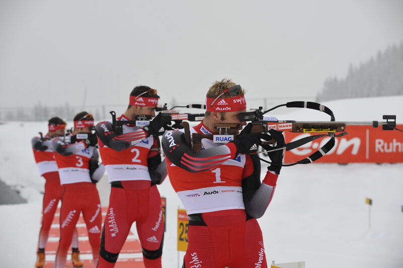 Biathletes shooting in snow