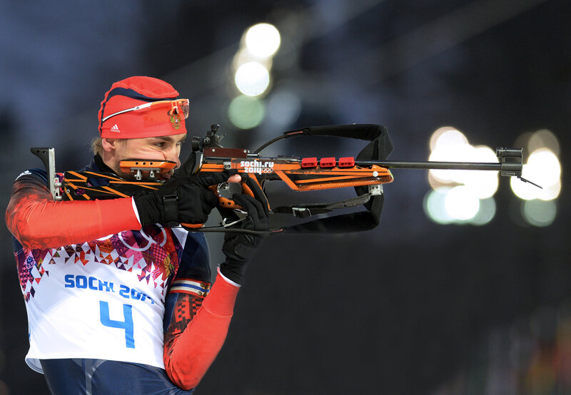 Biathlon athlete aiming rifle