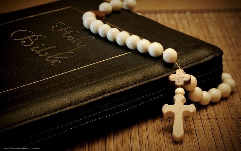 Bible and rosary on bamboo