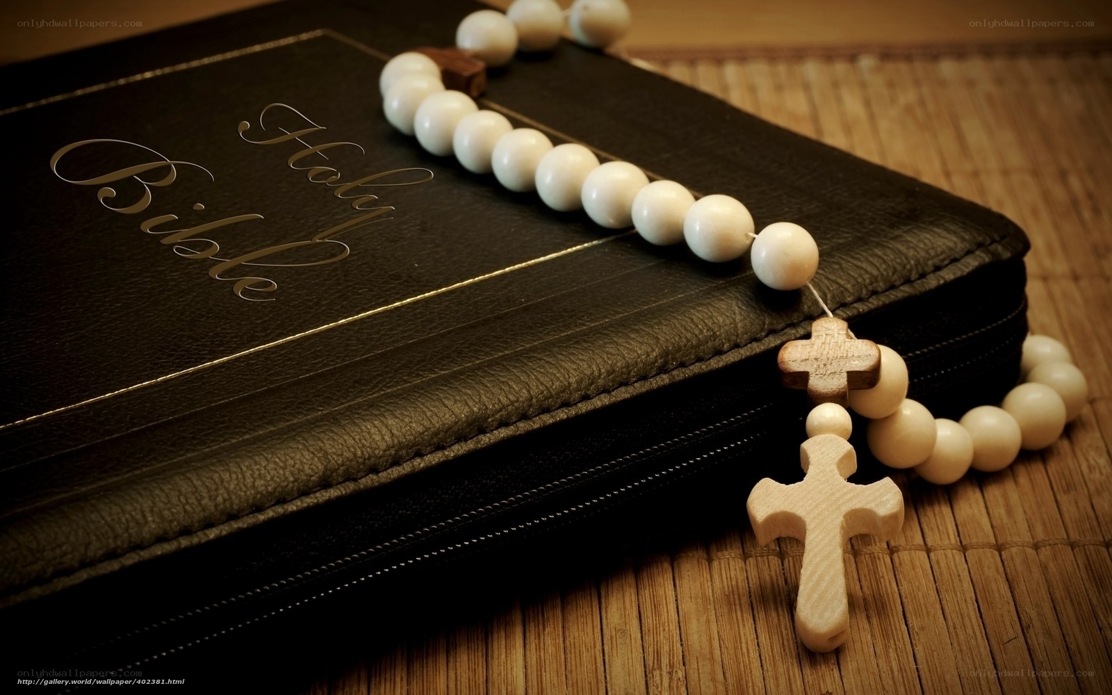 Bible and rosary on bamboo