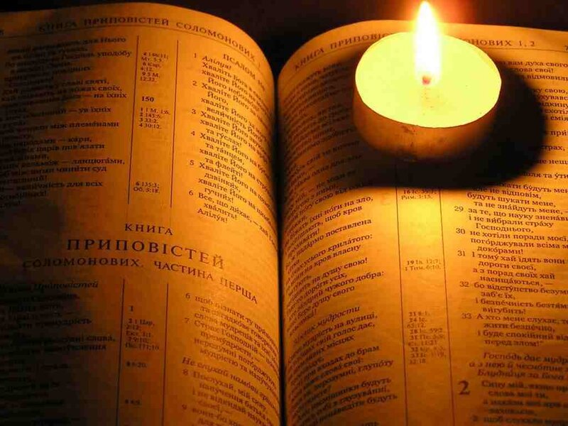 Bible with candlelight reading