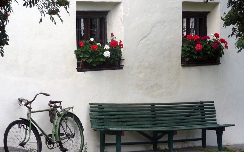 Bicycle and bench by flower boxes