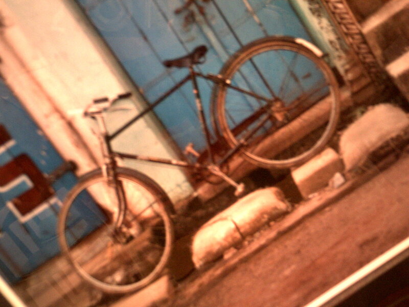 Bicycle leaning against a blue wall