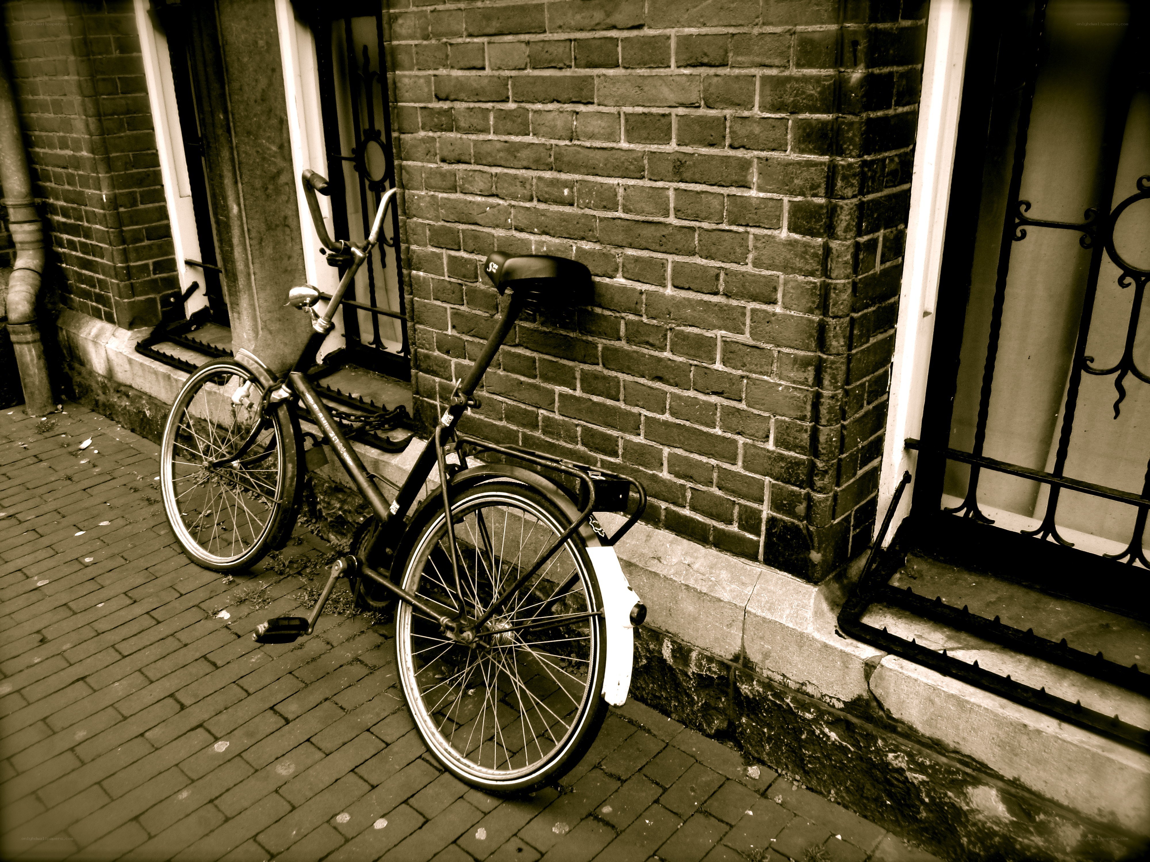 Bicycle leaning against a brick wall