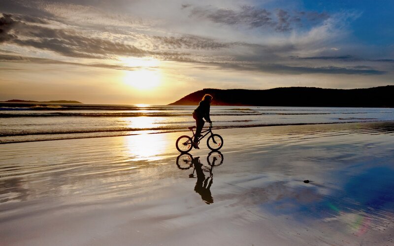 Bicycle on beach at sunset