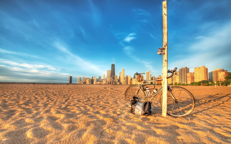 Bicycle on beach with city skyline