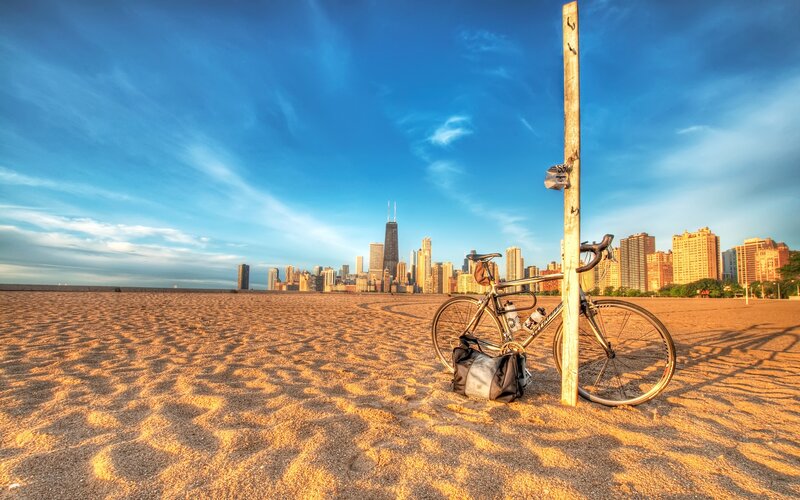 Bicycle on beach with city skyline