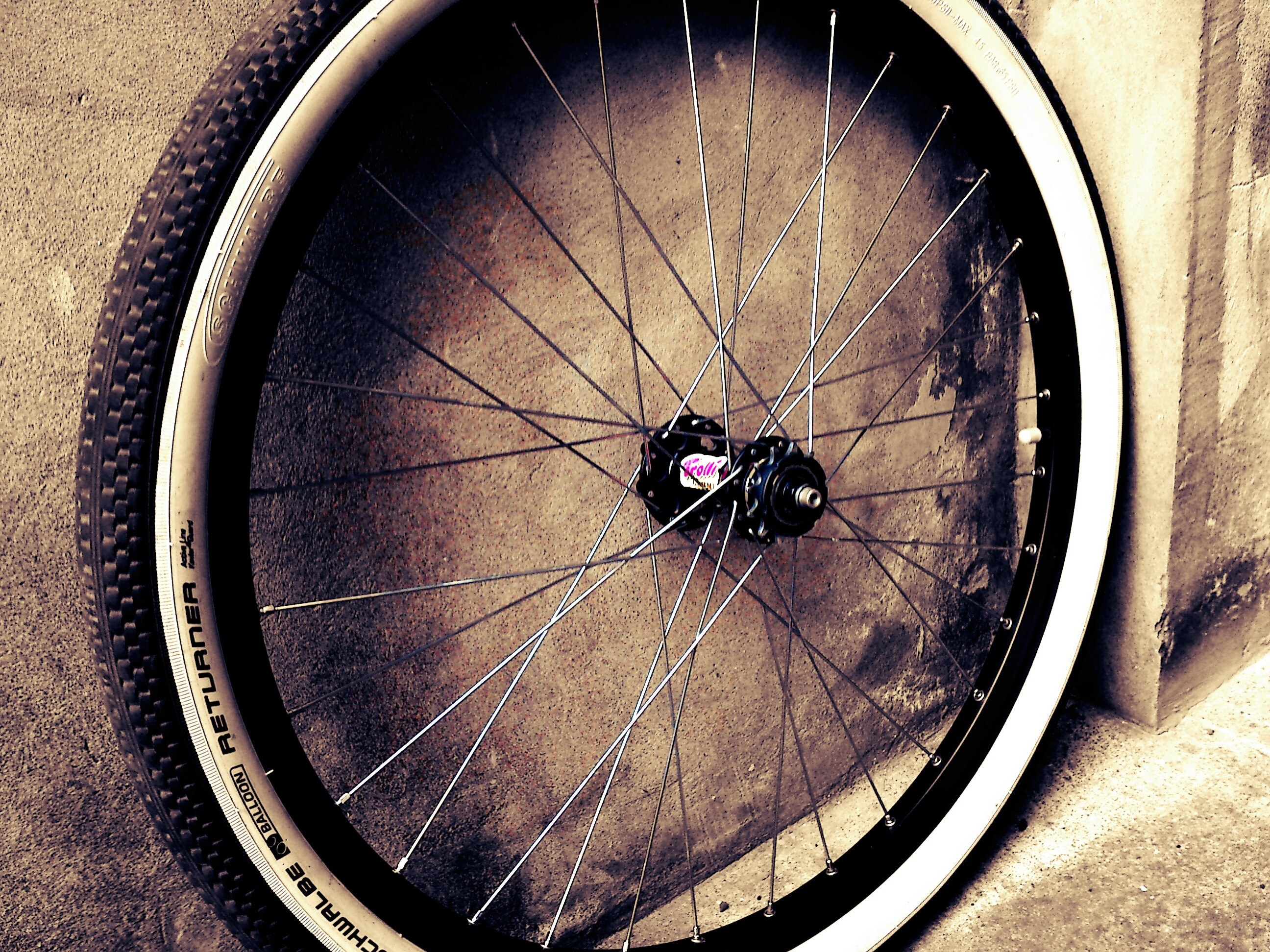 bicycle wheel against concrete wall