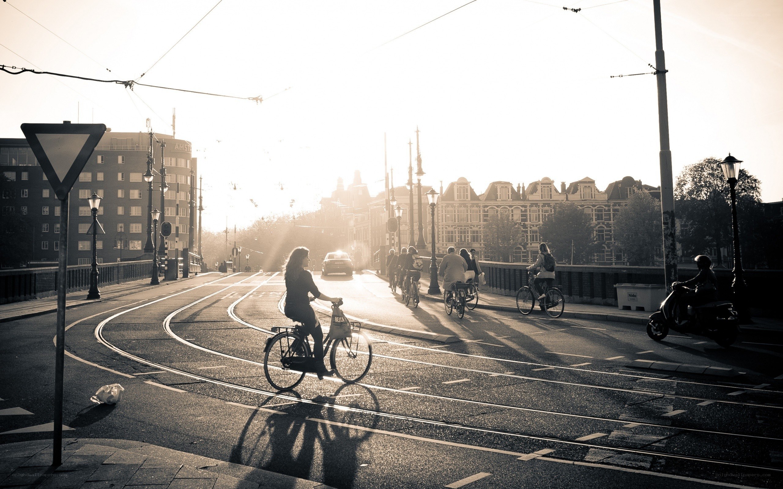 Bicyclists on a bridge at sunrise