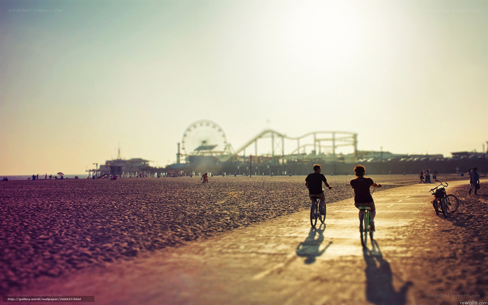 Bicyclists on the beach at sunset