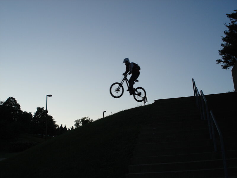 biker jumping stairs at dusk