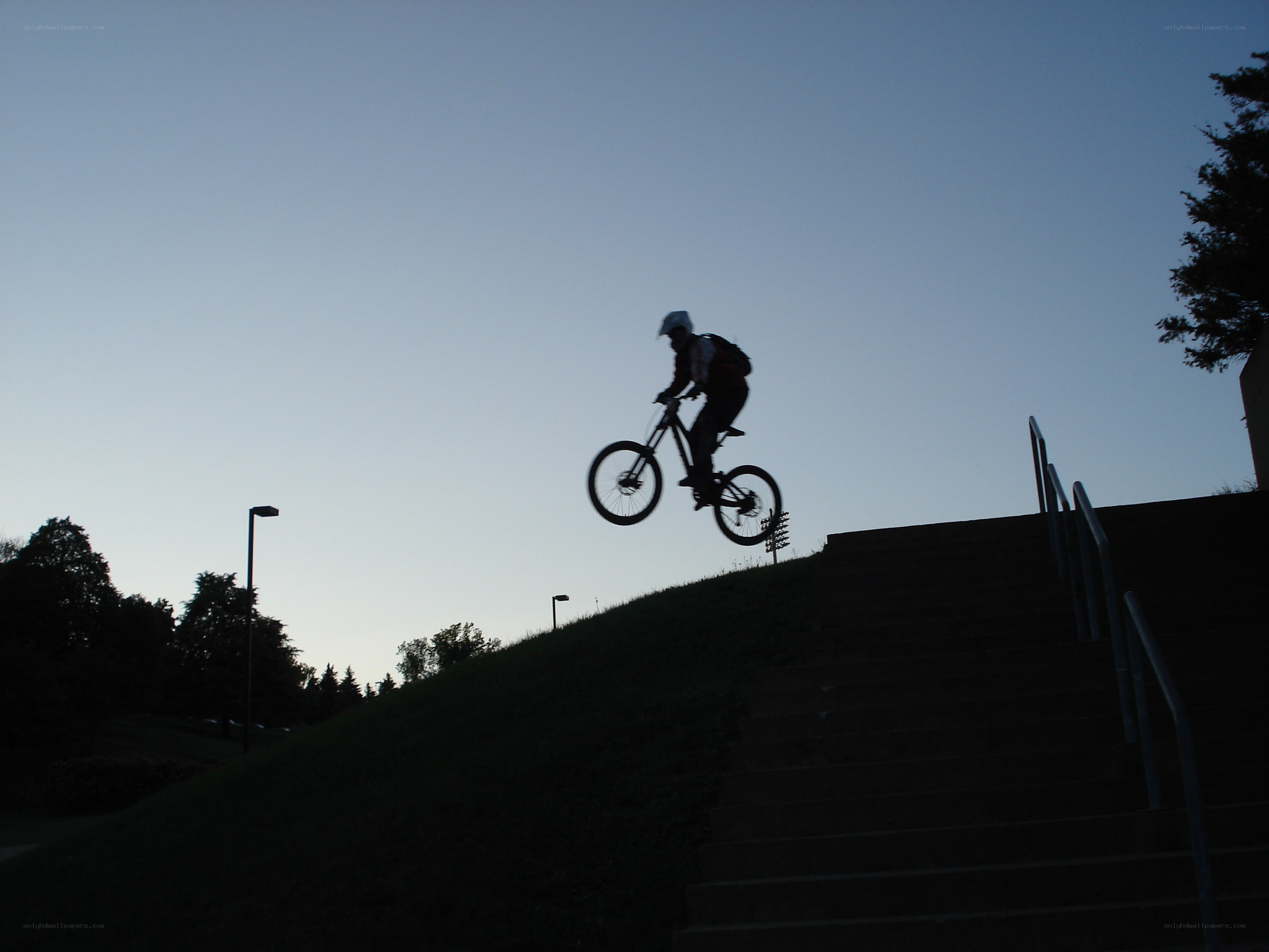 biker jumping stairs at dusk