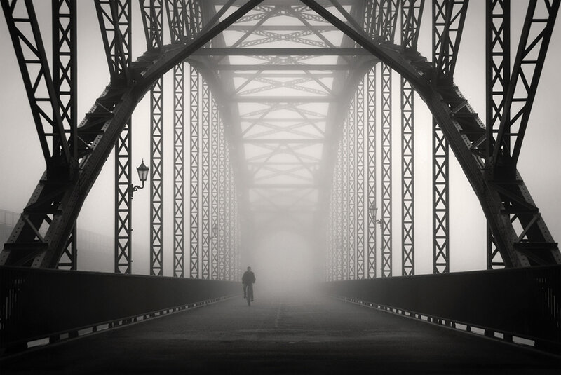 Biker on a foggy bridge