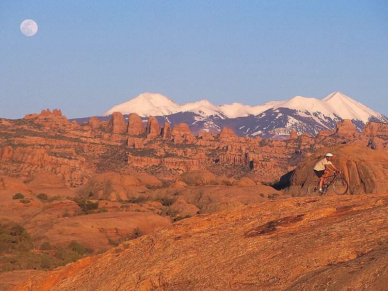 Biker on red rock with moon