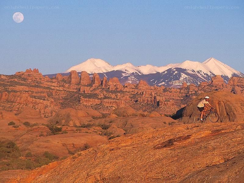 Biker on red rock with moon