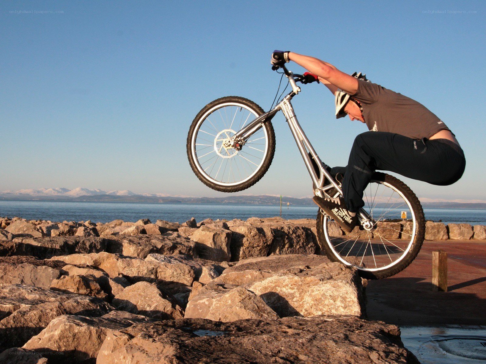 Biker performing wheelie on rocks