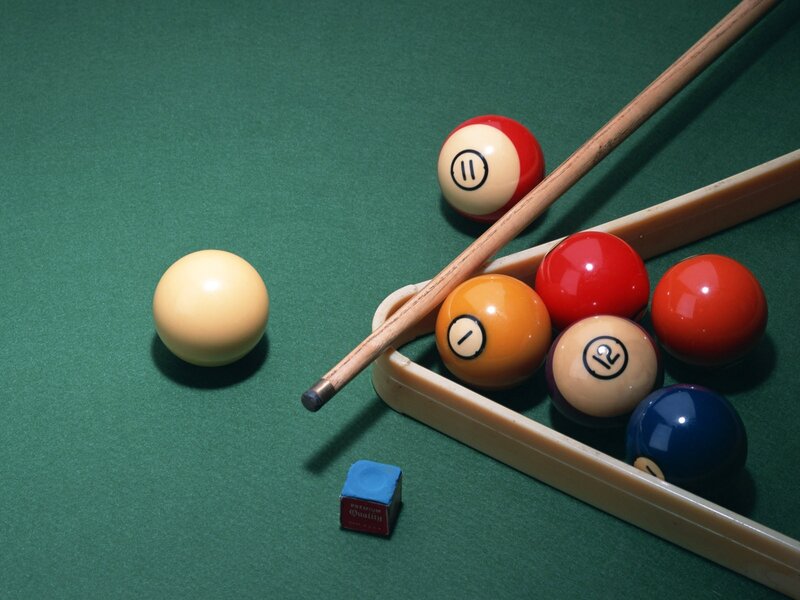 Billiards balls and cue on green felt