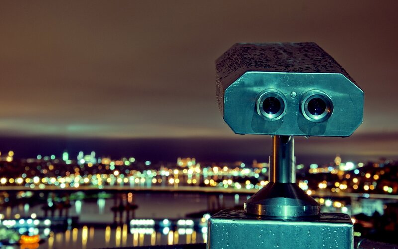 Binoculars overlooking city at night