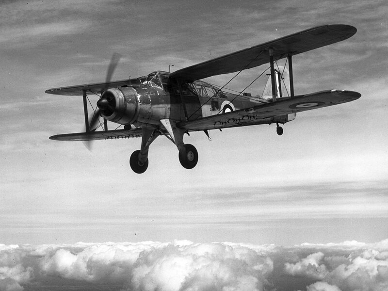 Biplane flying above clouds