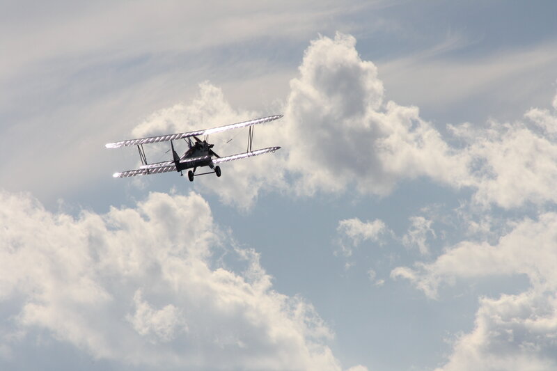 biplane flying in cloudy sky