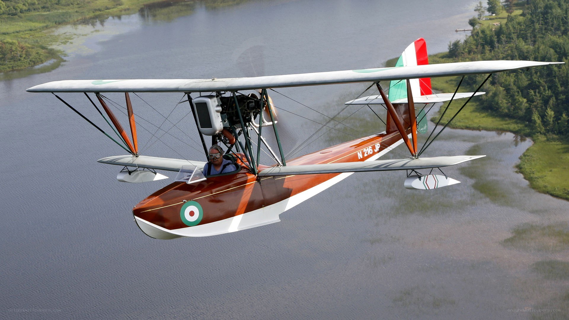 biplane flying over a lake