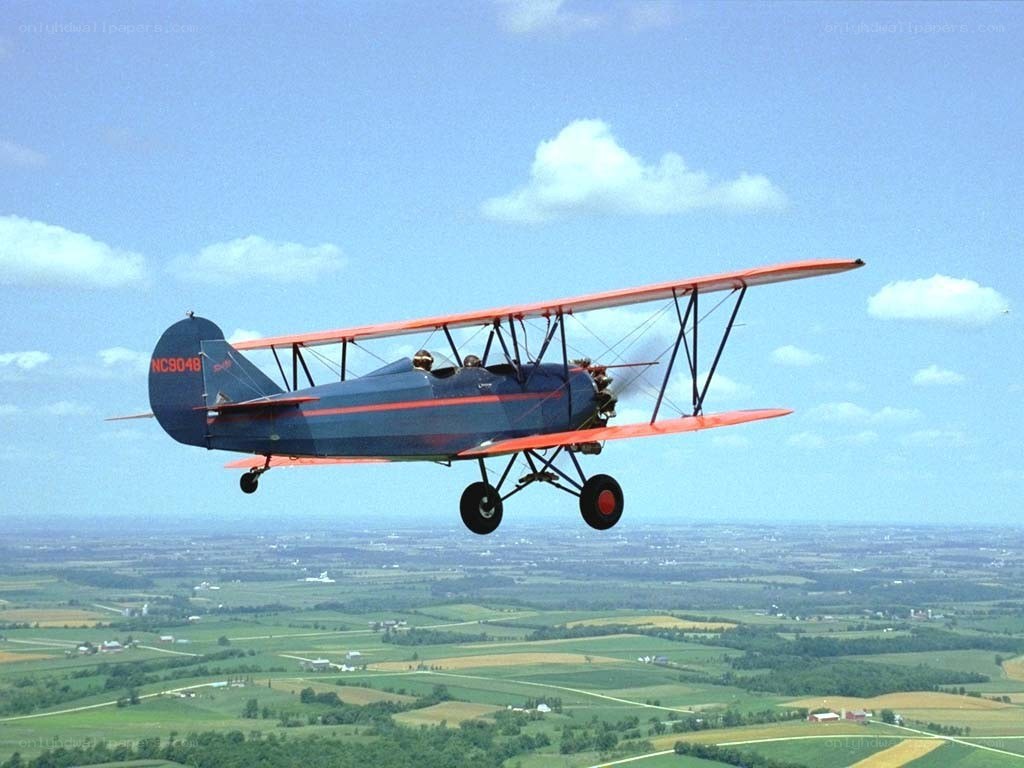 Biplane flying over countryside
