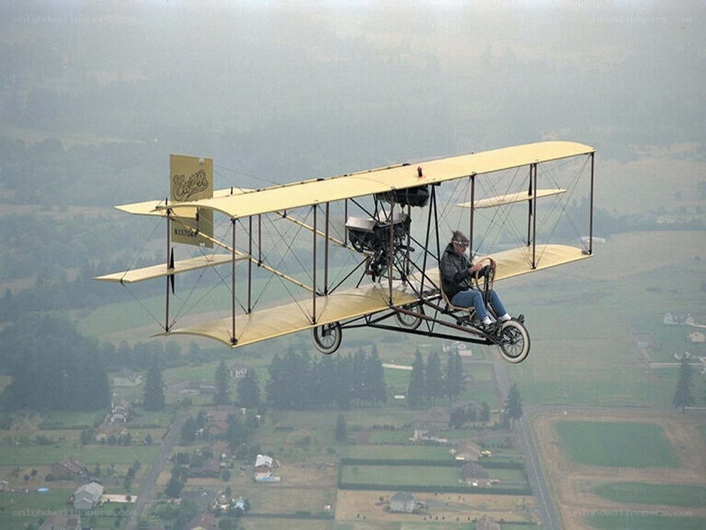 biplane flying over countryside