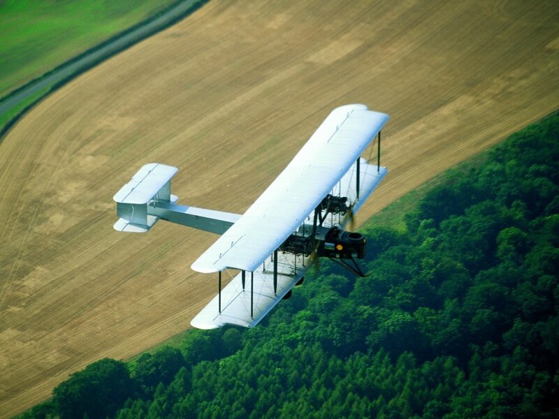 Biplane flying over fields