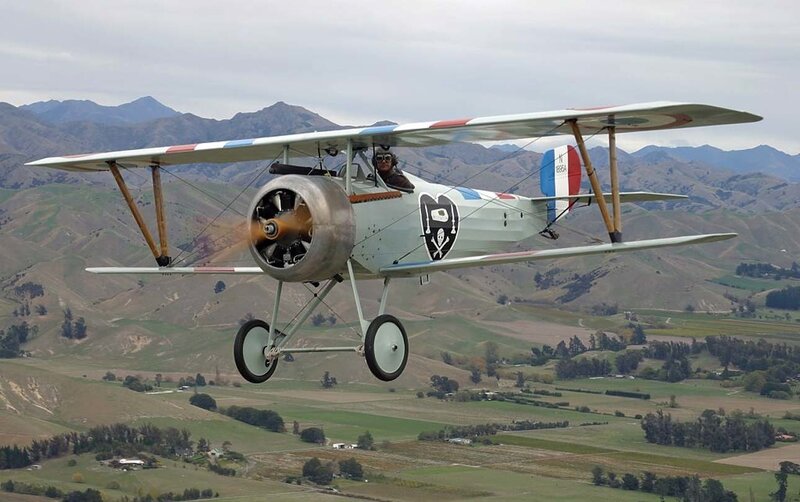 biplane flying over mountains