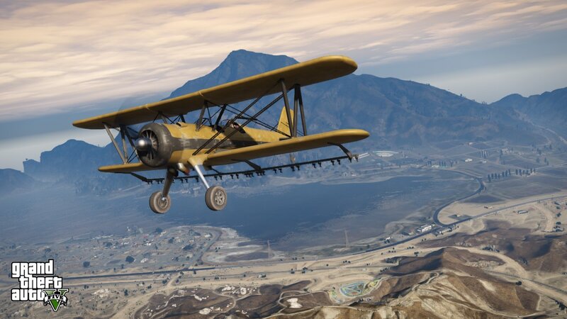 biplane flying over mountains