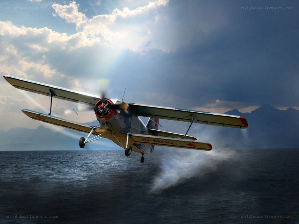 Biplane flying over ocean