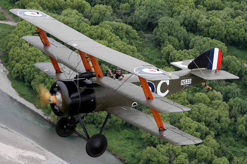 biplane flying over river