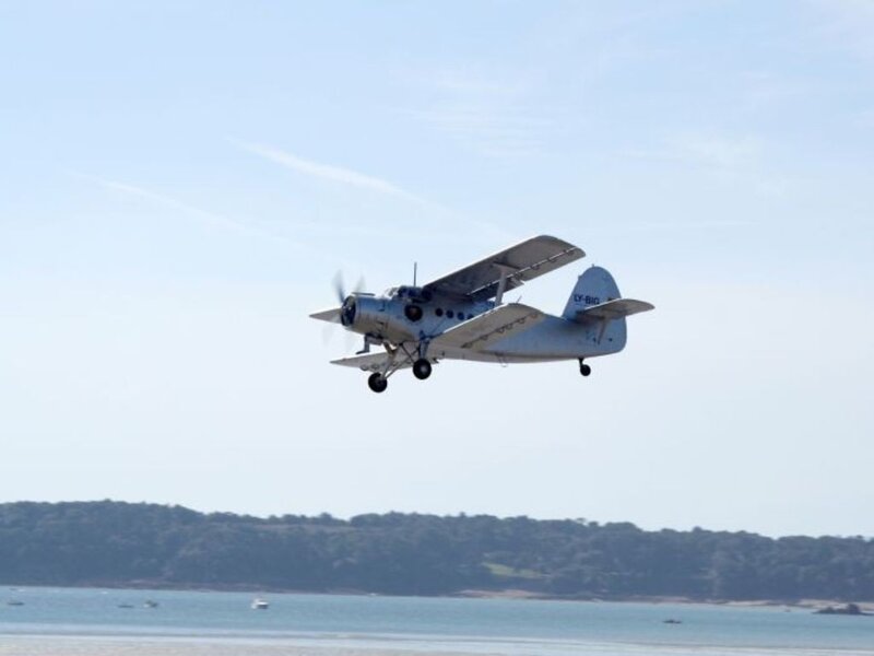 biplane flying over water