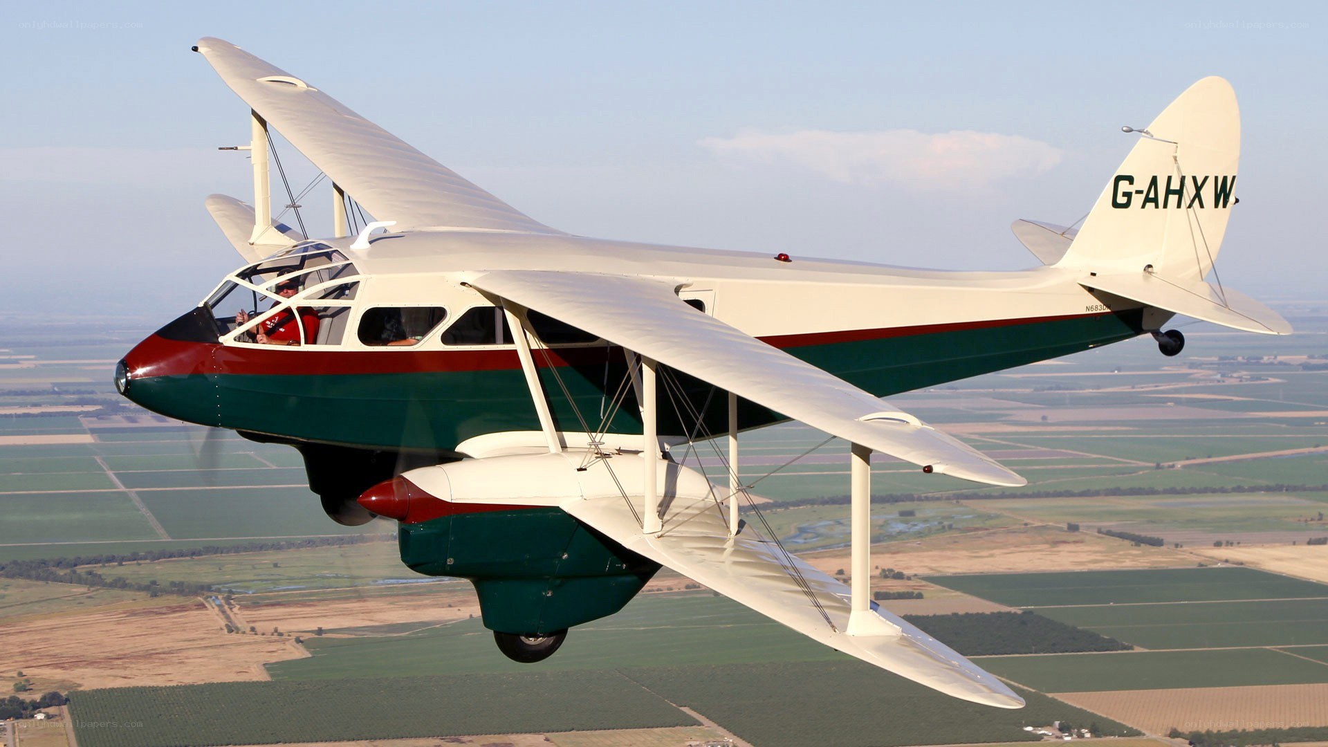 biplane in flight over fields