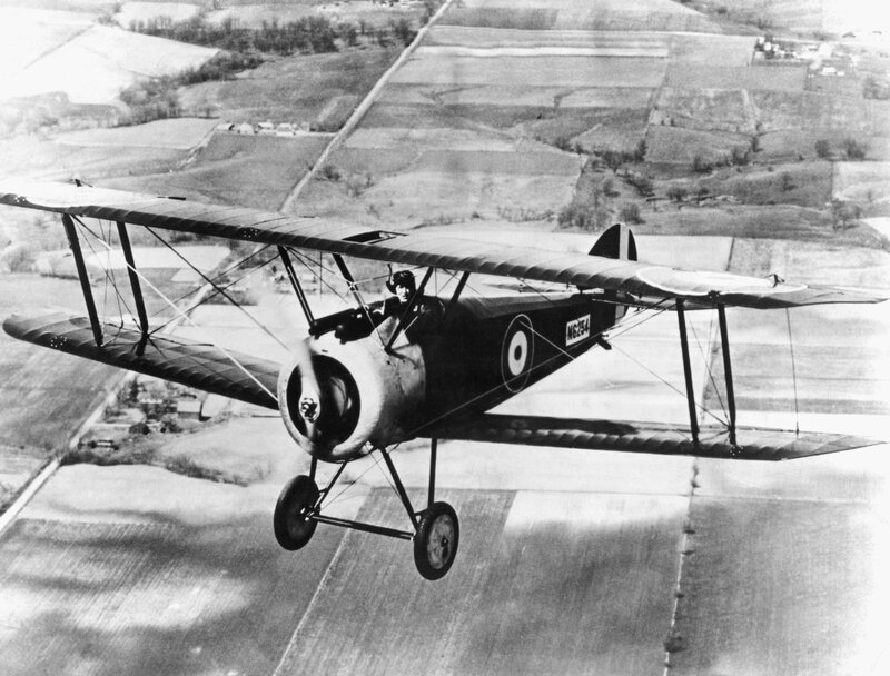 biplane in flight over fields