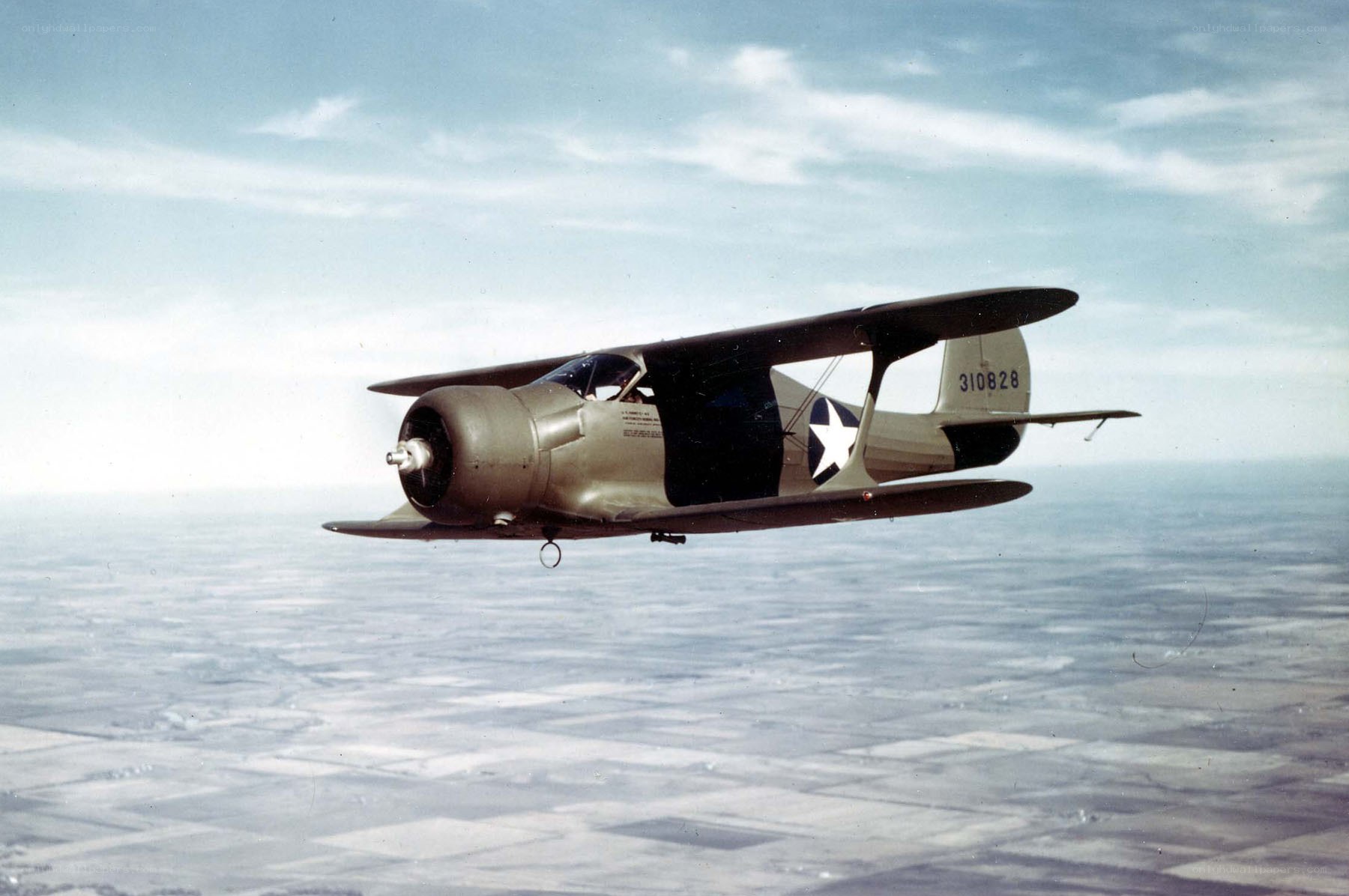Biplane in flight over landscape