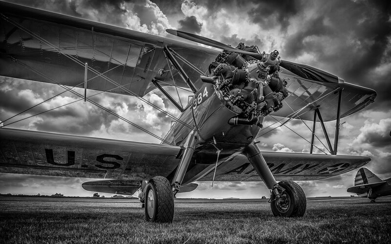 Biplane on Grass Field — Black, Dramatic