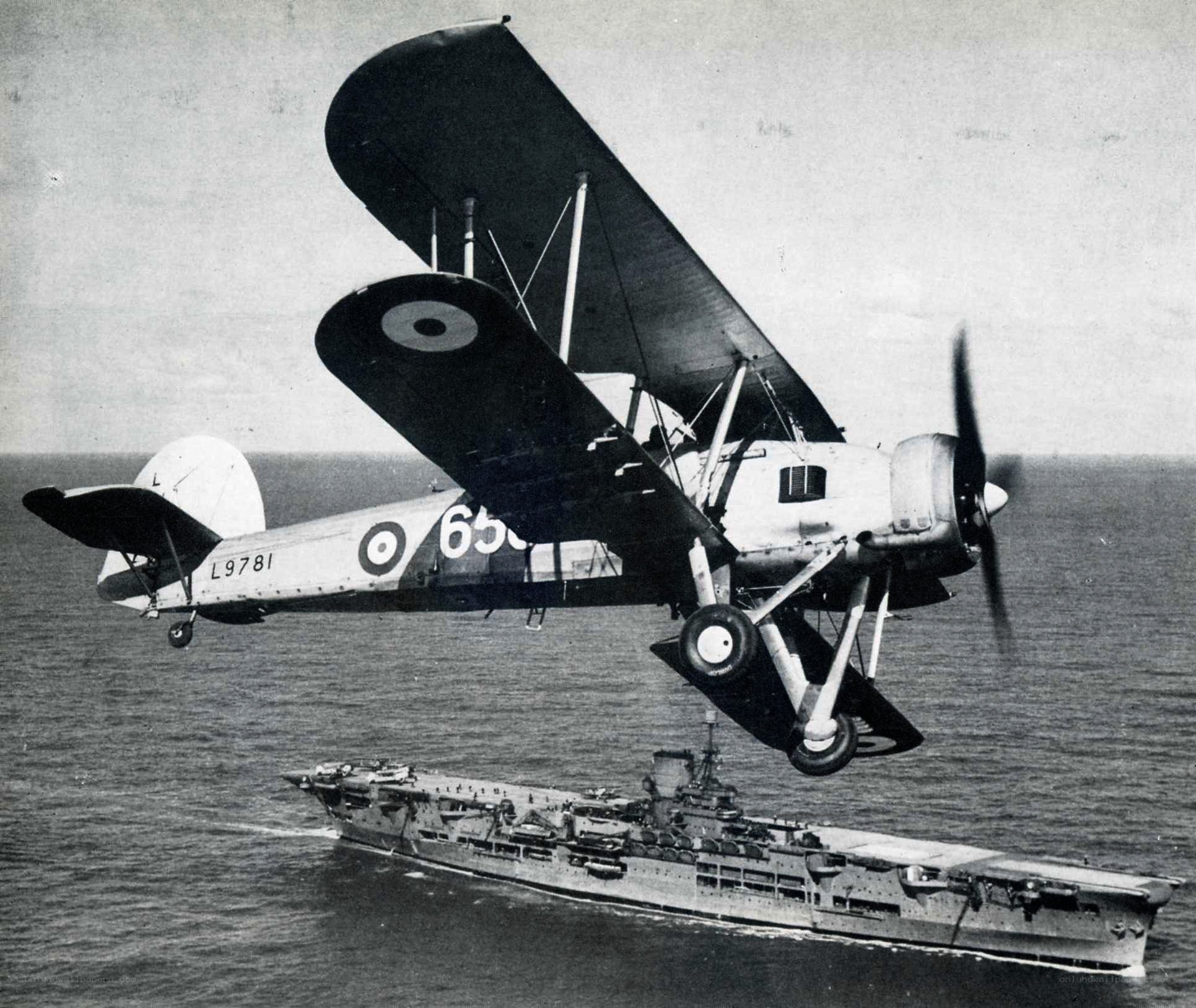 biplane over aircraft carrier