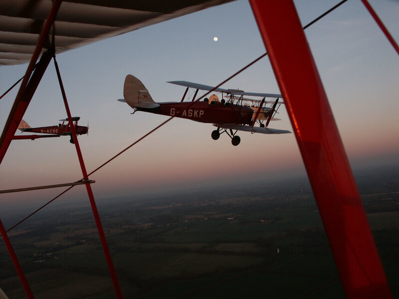 Biplanes flying at dusk