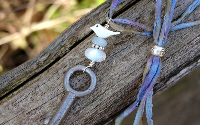 bird and key necklace on wood