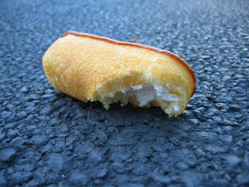Bitten corn dog on pavement