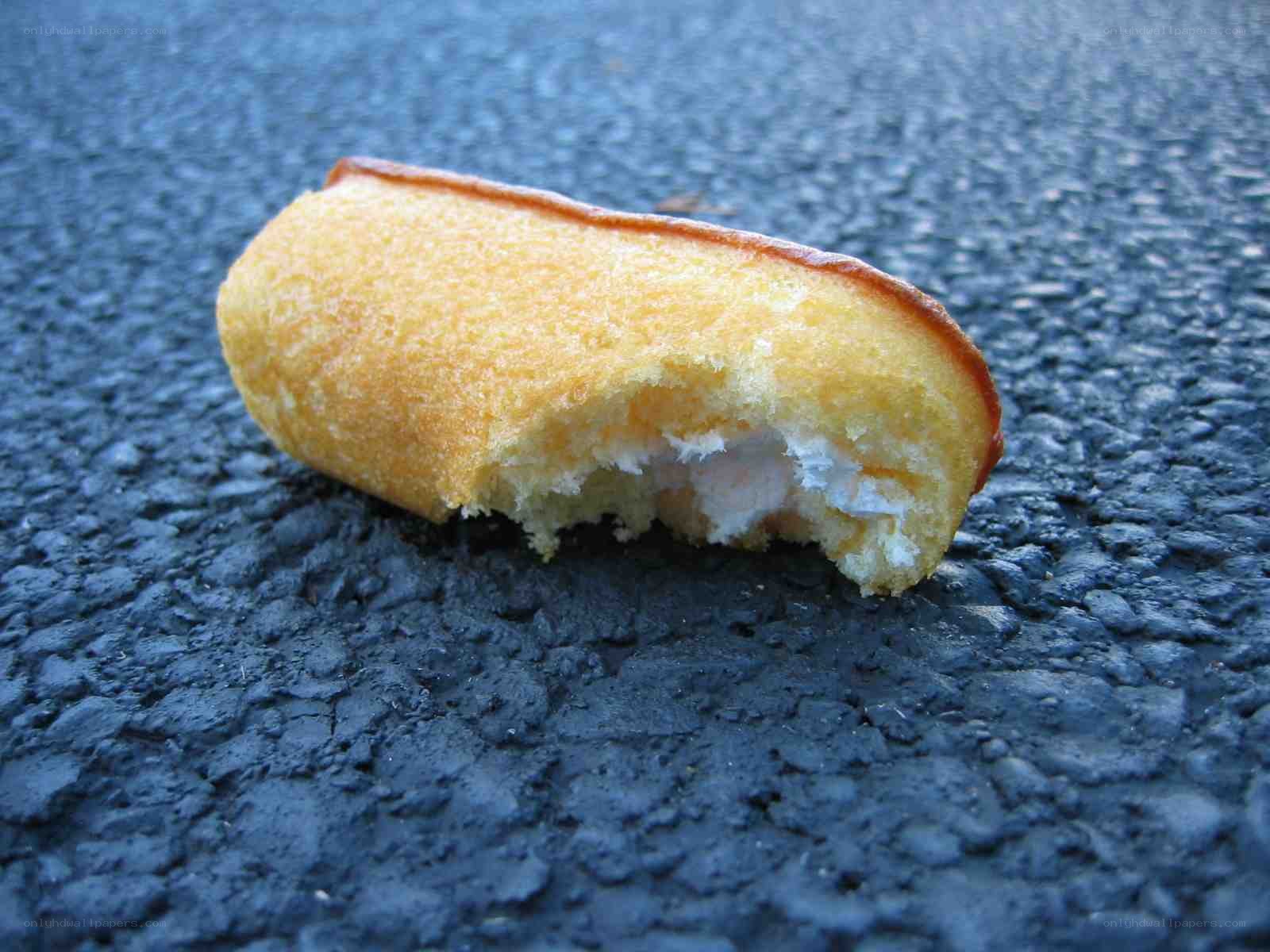 Bitten corn dog on pavement