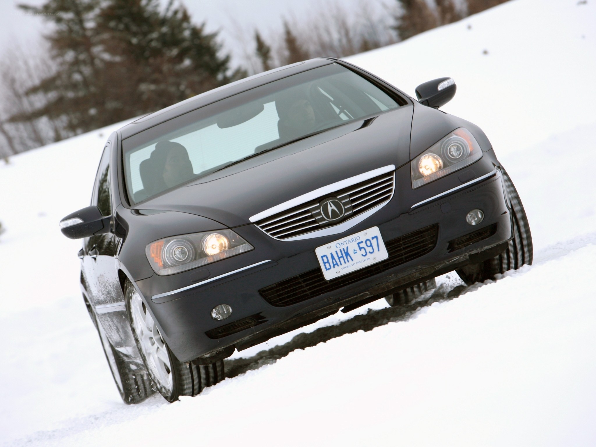 Black Acura driving in snow