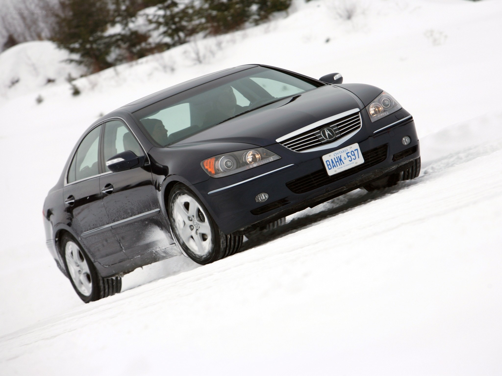 Black Acura driving on snow